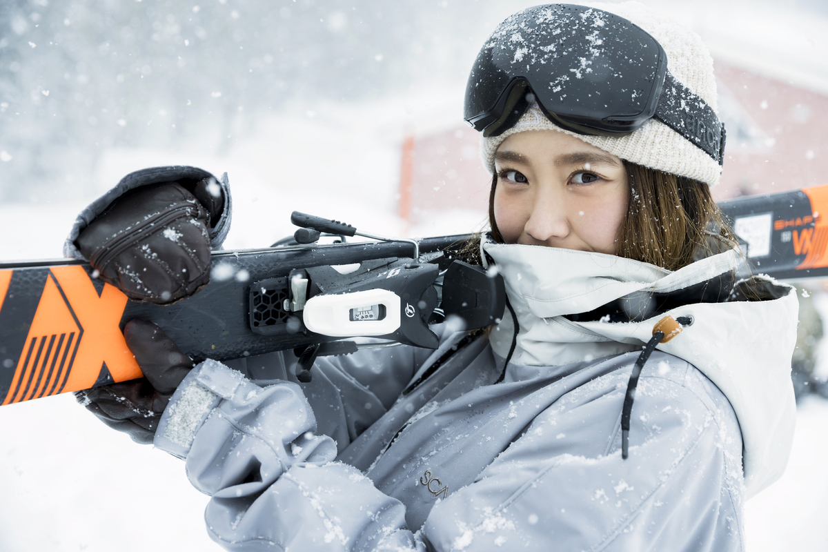 在滑雪場扛著雙板滑雪板的女性